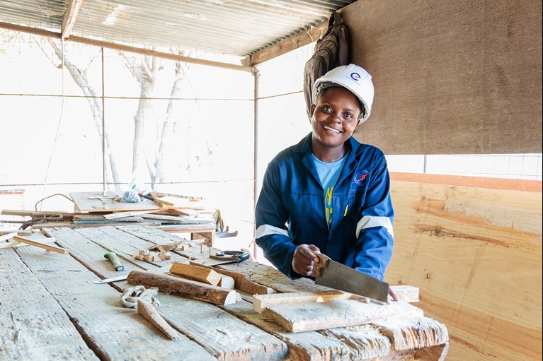 Memory sawing a piece of timber in a workshop. Photo: Tim Lam/Caritas Australia 