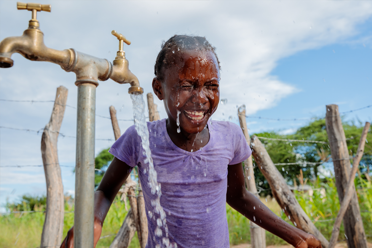 Thandolwayo (9) from Tanzania washes her face from the new water pipe, installed in her village with the support of Caritas Australia. Before the pipe was installed, Thandolwayo and other members of the community had to walk over 5km one way at least once a day down a steep and dangerous hill to collect dirty water from the Gweyi river. She would often get sick and miss school from illness and being tired from collecting water. Photo credit: Richard Wainwright/Caritas Australia.