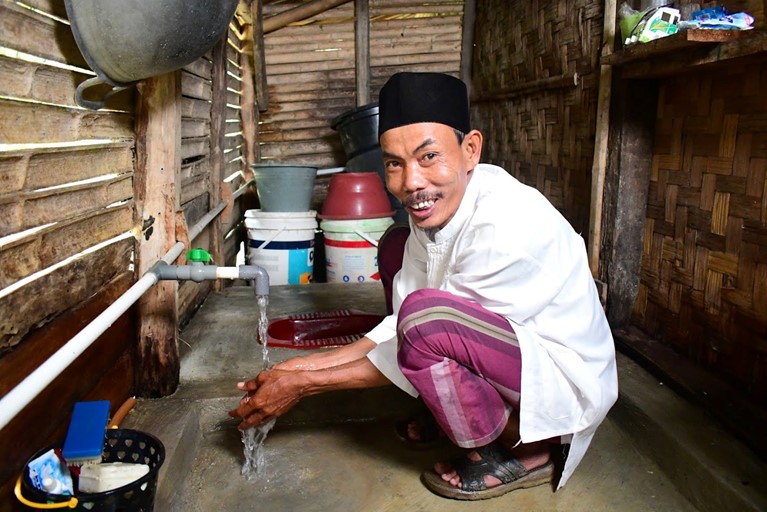 Arsad from Indonesia did not have a toilet or running water in his house until 2019 and had to walk a long distance to Open Defecation (OD) areas such as the forest or under trees, sometimes accompanying his wife at night, with the threat of snakes along the way. OD caused poor health, a dirty neighbourhood and family and community fights. Caritas Australia local partner Laz Harfa ran a Community Led Total Sanitation (CLTS) program is his community and through this he became a trusted community leader and hygiene advocate. Photo credit: Richard Wainwright/Caritas Australia.